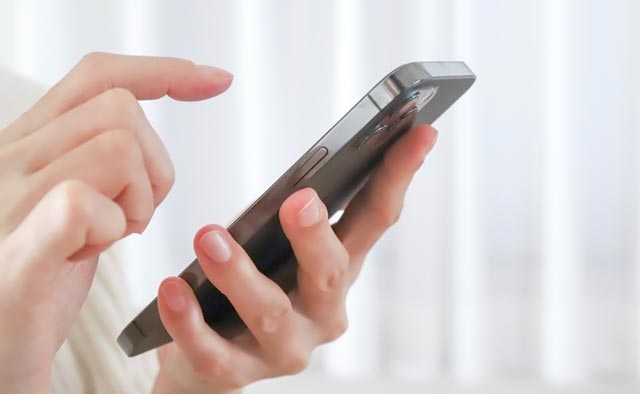 家族葬の調布市葬儀社に電話でお問合せしようとしている人の手元。